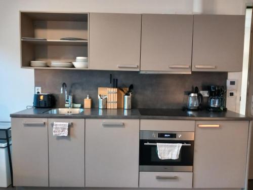 a kitchen with white cabinets and a stove at Charming Retreat Apartment City 20Alpha in Delft