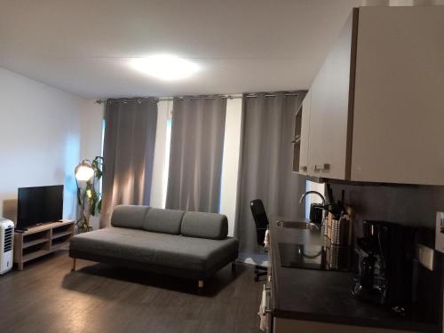 a living room with a couch in front of a window at Charming Retreat Apartment City 20Alpha in Delft