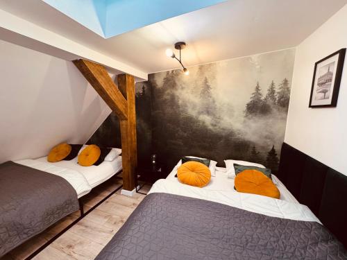 a bedroom with two beds with orange pillows at KOBIELA Luxury LOFT City Center in Katowice