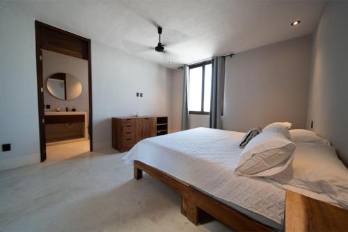 a bedroom with a large bed and a mirror at Casa Almendros II Punta de Mita in Punta Mita