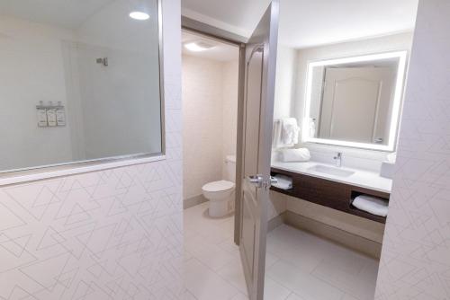 a bathroom with a sink and a toilet and a mirror at Holiday Inn Express - Neptune by IHG in Neptune City