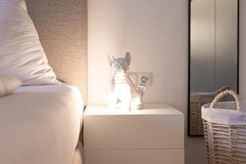 a toy dog on a night stand next to a bed at Lebe`schlitters - Das Ferienapartmenthaus im Zillertal in Schlitters