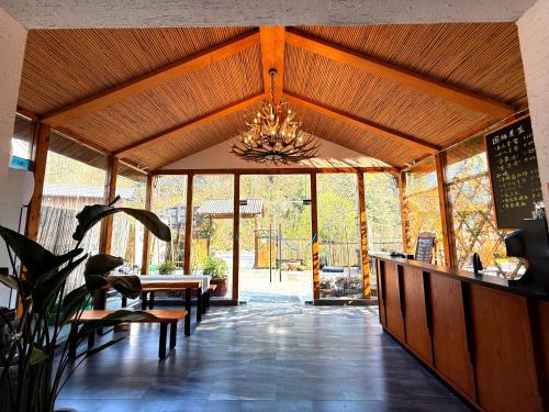 a living room with a chandelier and a table at Zhangjiajie Forest Park Youth Hostel in Zhangjiajie