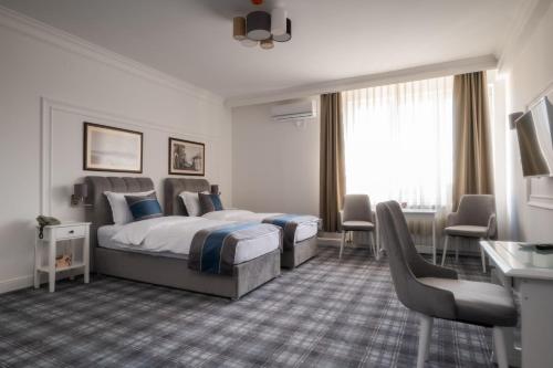 a hotel room with a bed and a desk and chairs at Hotel Mio City in Kula
