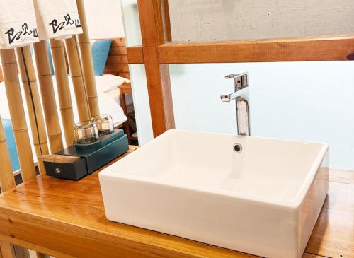 a white sink sitting on top of a wooden counter at Zhangjiajie Forest Park Youth Hostel in Zhangjiajie