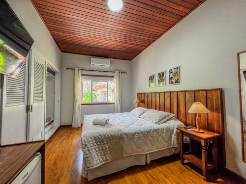 a bedroom with a bed and a wooden ceiling at Pousada Victoria Villa By Nacional Inn - A 800 metros da Vila Capivari in Campos do Jordão