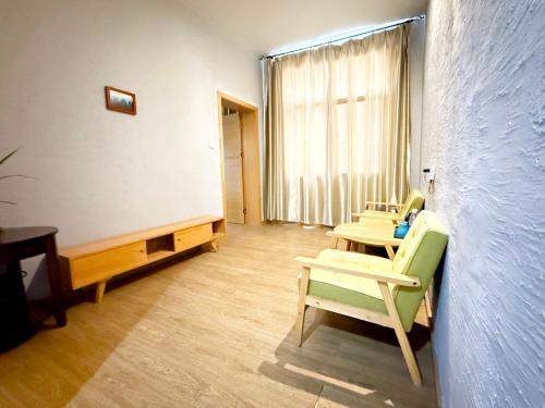 a room with chairs and a table and a window at Zhangjiajie Forest Park Youth Hostel in Zhangjiajie