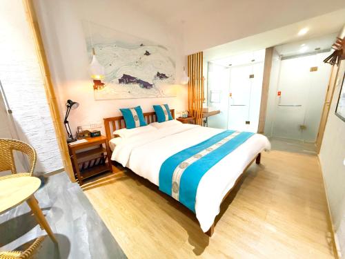 a bedroom with a large bed with blue pillows at Zhangjiajie Forest Park Youth Hostel in Zhangjiajie