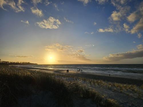 a beach with people walking on the sand and the ocean at _Residenz Meeresblick_ Haus B _ Wh in Rerik