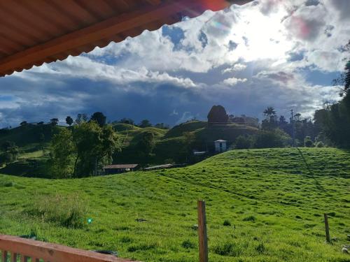 a green field with a hill in the background at La Vaca Fifí in Murillo