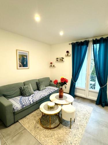 un salon avec un canapé vert et une table dans l'établissement Luxury Appartement, à Livry-Gargan