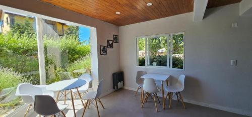 a room with two tables and chairs and a window at Hostel Aonikenk in El Calafate