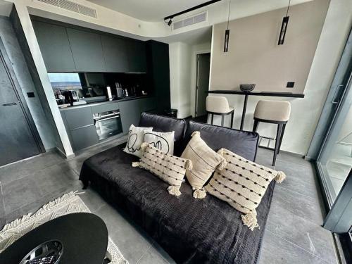 a living room with a couch and a kitchen at Corner 1 Bed Apart in Mercury Suites with Rooftop Pool Seasonal in St. Julianʼs