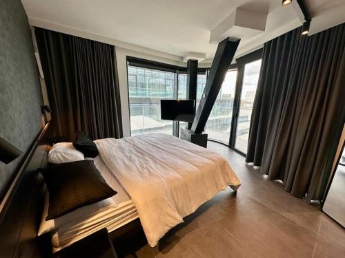 a bedroom with a large bed and a large window at Corner 1 Bed Apart in Mercury Suites with Rooftop Pool Seasonal in St. Julianʼs