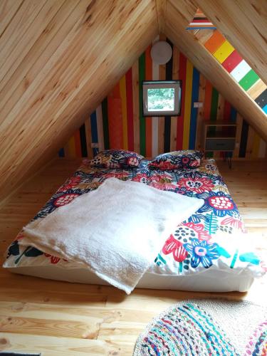 a bed in the corner of a room in a attic at Domek na Czapli in Morzyczyn