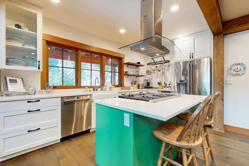 a kitchen with white cabinets and a green island with chairs at Snoqualmie Lodge in Snoqualmie Pass