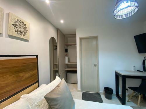 a bedroom with a bed and a desk and a table at Maidy Luxury Hotel in Medellín