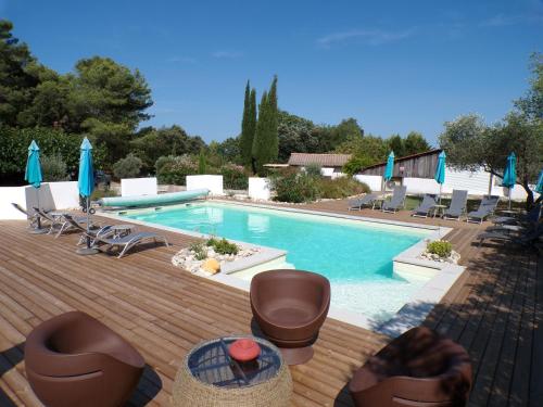 une piscine avec chaises et parasols dans l'établissement Gîte le Relais de la Cavayere, à Carcassonne