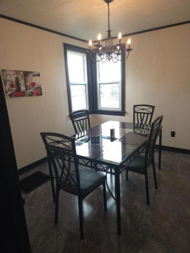 a dining room with a table and chairs and a chandelier at Minutes to Downtown & Ideal for Long-term Stays in Kingston