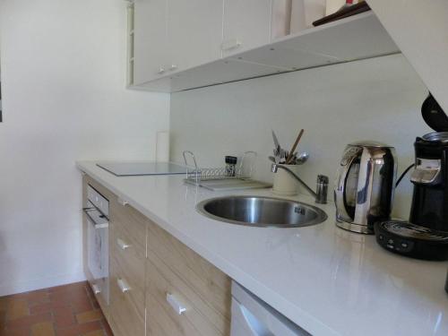 une cuisine avec un évier et un plan de travail dans l'établissement Les Rives de Capbreton Villa patio Résidence pour 4 personnes, à Capbreton