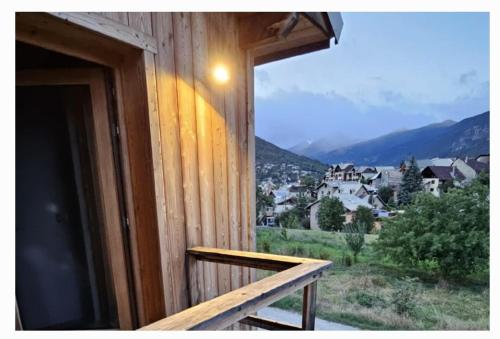 d'un balcon avec une fenêtre offrant une vue sur la ville. dans l'établissement Appartement Chalet - intégralité du logement 6 pers max, à Briançon