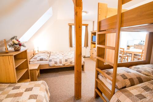a bedroom with two bunk beds and a table at Chalupa 101 in Vítkovice