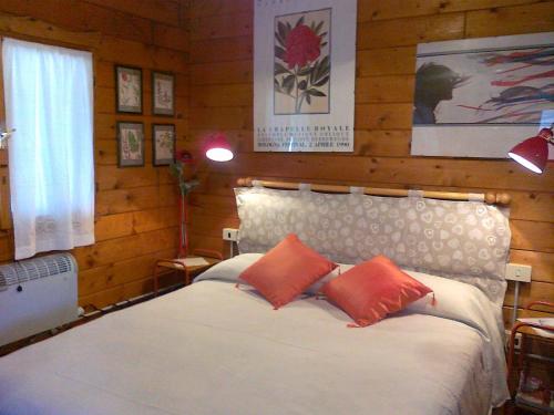 a bedroom with a bed with two orange pillows at L'Amabile Geko in Rio Marina