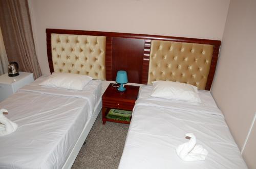 two beds in a room with swans on a table at Continental Inn Hotel Al Farwaniya in Kuwait