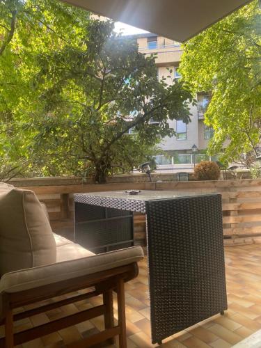 d'une terrasse avec une table, une chaise et un ordinateur portable. dans l'établissement Appartement terrasse proche paris, à Saint-Cloud