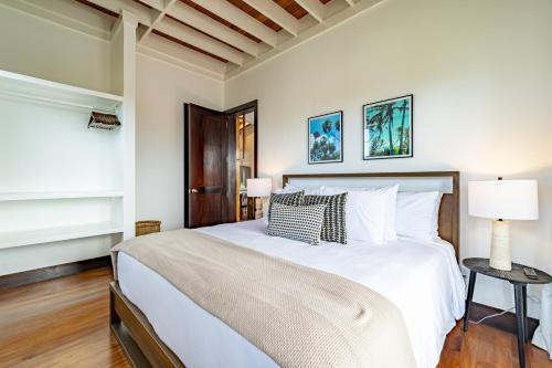 ein Schlafzimmer mit einem großen weißen Bett und zwei Lampen in der Unterkunft Vista de Azul and The Pool Club at Mahogany Bay in San Pedro