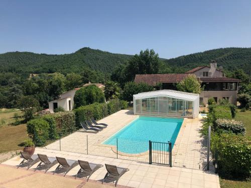 a swimming pool with chairs and a house at Maison de charme à Saint-Géry avec piscine partagée in Saint-Géry
