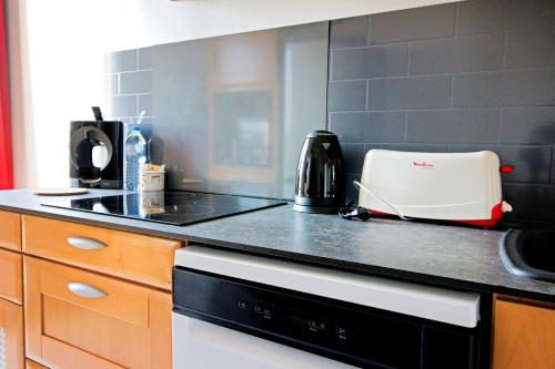 a kitchen with a black counter top with a toaster at Comme à la maison entre Fontainebleau et Moret sur Loing in Champagne-sur-Seine