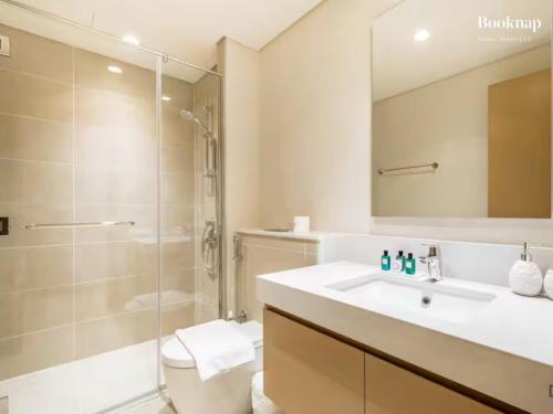 a bathroom with a sink and a shower and a toilet at Lavish 3BR Apartment with Assistant Room in Habour Gate Tower in Dubai