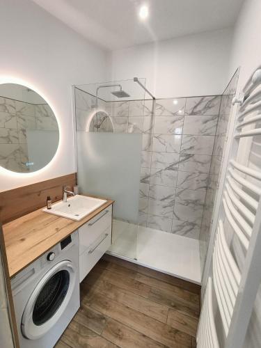 une salle de bain avec une machine à laver et un lavabo dans l'établissement Maison 4 pers 300m de la mer, à Saint-Brévin-les-Pins