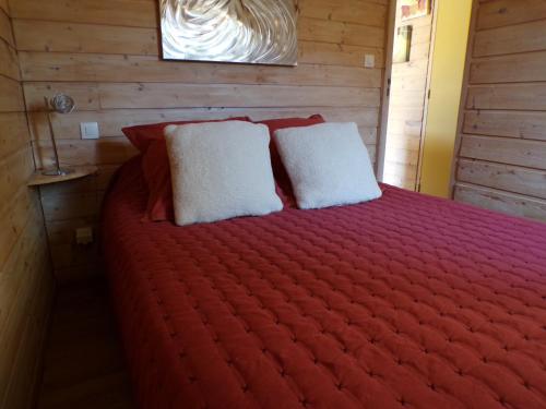 a bedroom with a red bed with two white pillows at Gîte Carcassonne le Relais de la Cavayere in Carcassonne