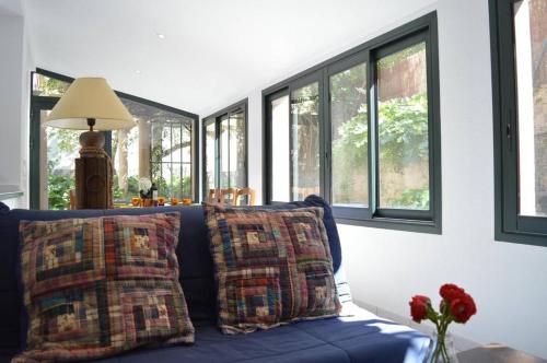 - un canapé bleu avec des oreillers dans une chambre avec des fenêtres dans l'établissement Appart 4 pièces 5 couchages BANYULS SUR MER BN250-001, à Banyuls-sur-Mer