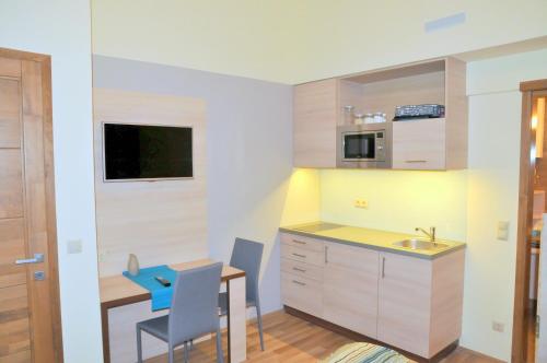 a small kitchen with a table and a blue stool at Frank & Fang Apartments in Budapest