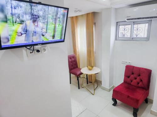 a room with a flat screen tv on a wall at Hôtel Résidence Saint James Maguerita in Douala
