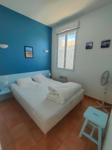 - une chambre avec un grand lit blanc et un mur bleu dans l'établissement Apartment in residence with swimming pool and beach 200m away, à Saint-Jean-de-Monts