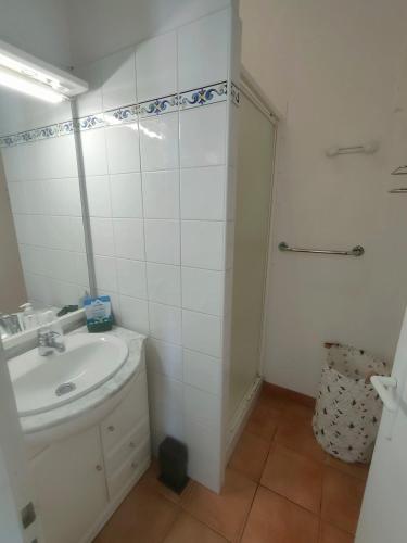 une salle de bain blanche avec un lavabo et une douche dans l'établissement Apartment in residence with swimming pool and beach 200m away, à Saint-Jean-de-Monts