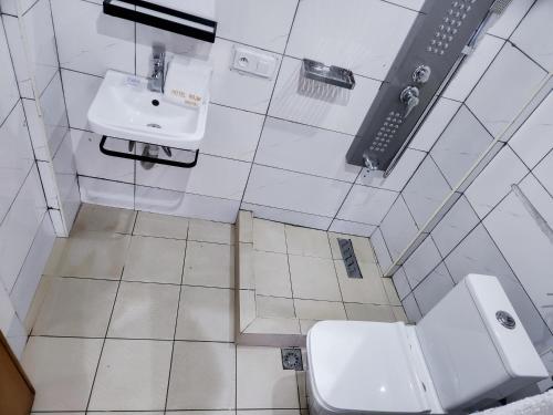 a bathroom with a toilet and a sink at Hôtel Résidence Saint James Maguerita in Douala