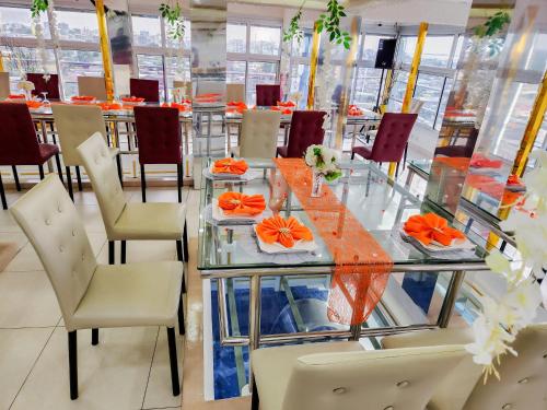 a dining room with a glass table and chairs at Hôtel Résidence Saint James Maguerita in Douala
