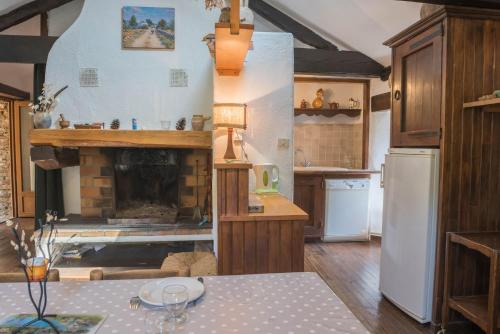une cuisine avec une cheminée au milieu dans l'établissement Gîte Gîtes de France 4/6 personnes à Campéménard, à Sainte-Croix-Vallée-Française