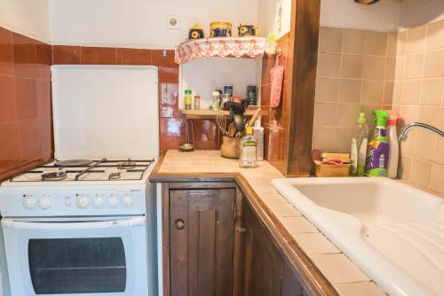 eine Küche mit einem weißen Herd oberer Ofen neben einer Spüle in der Unterkunft Gîte Gîtes de France 4/6 personnes à Campéménard in Sainte-Croix-Vallée-Française