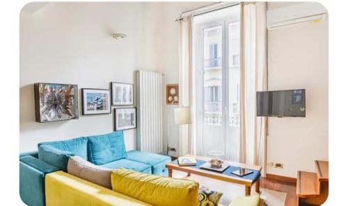 a living room with a blue couch and a tv at queen 24 in Taranto