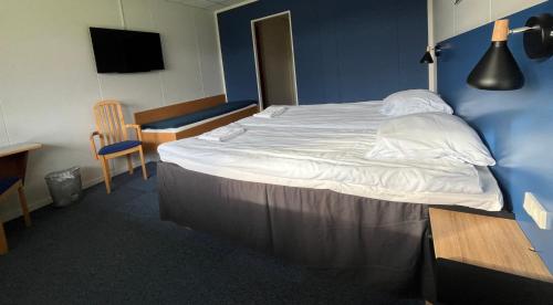 a bedroom with a large bed with a blue wall at BB-Hotel Herning "Messehotel" in Herning