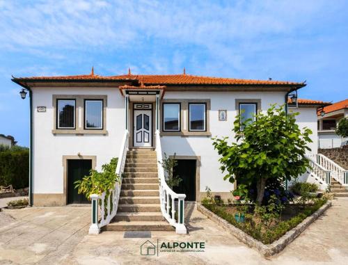 a white house with stairs in front of it at Desassossego Suites in Monção