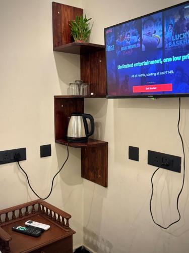 a living room with a tv and a table and a table at DIVINE BEACH INN - The sea shore hotel in Puducherry