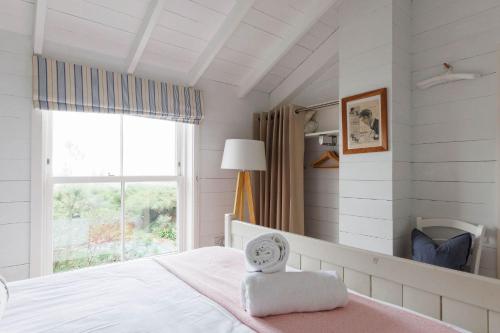 a bedroom with a bed with a clock on it at Beachfront House w Pool & Steam in West Wittering