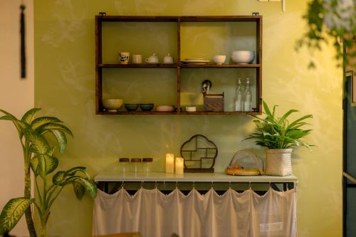 a shelf with dishes and candles on a wall at Du De Homestay in Hoi An